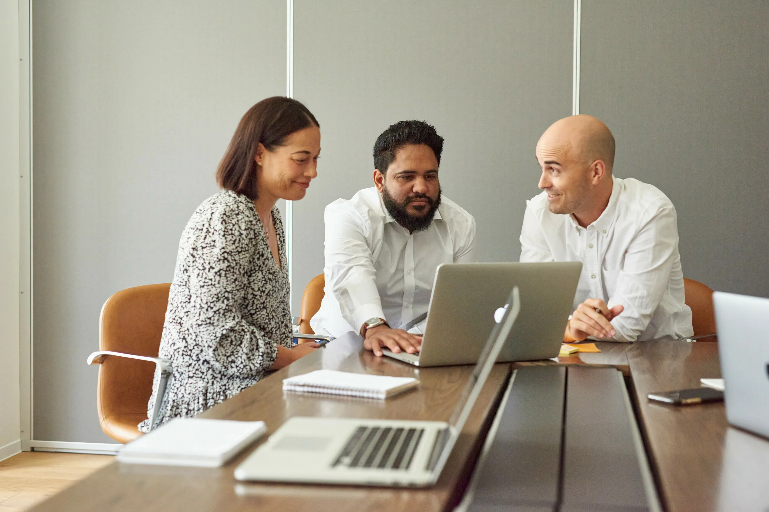 Business owners and an adviser reviewing finance options together