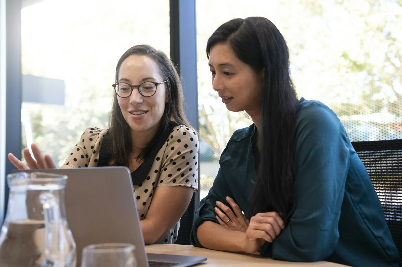 Two colleagues discussing information together at work