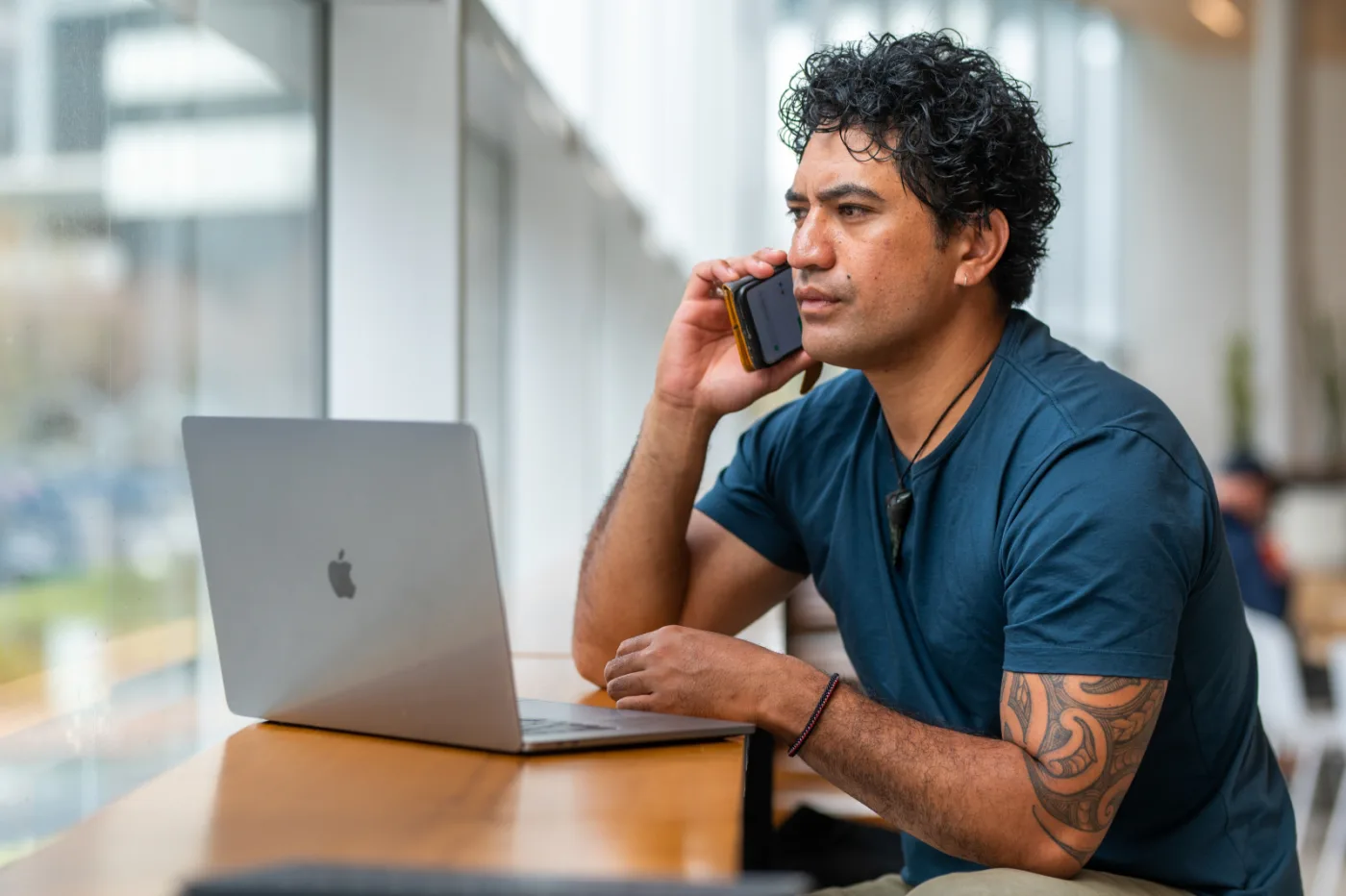 A man discussing insurance by phone while working on a laptop